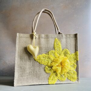 Yellow floral jute gift bag with bright sequin flower embellishment and heart charm – Pomme d’Or.