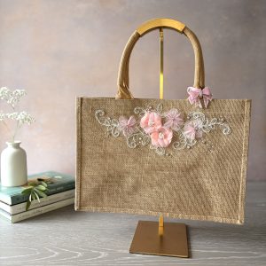 Hand embellished floral jute gift bag with pink blossom appliqué and decorative embroidery by Pomme d’Or.