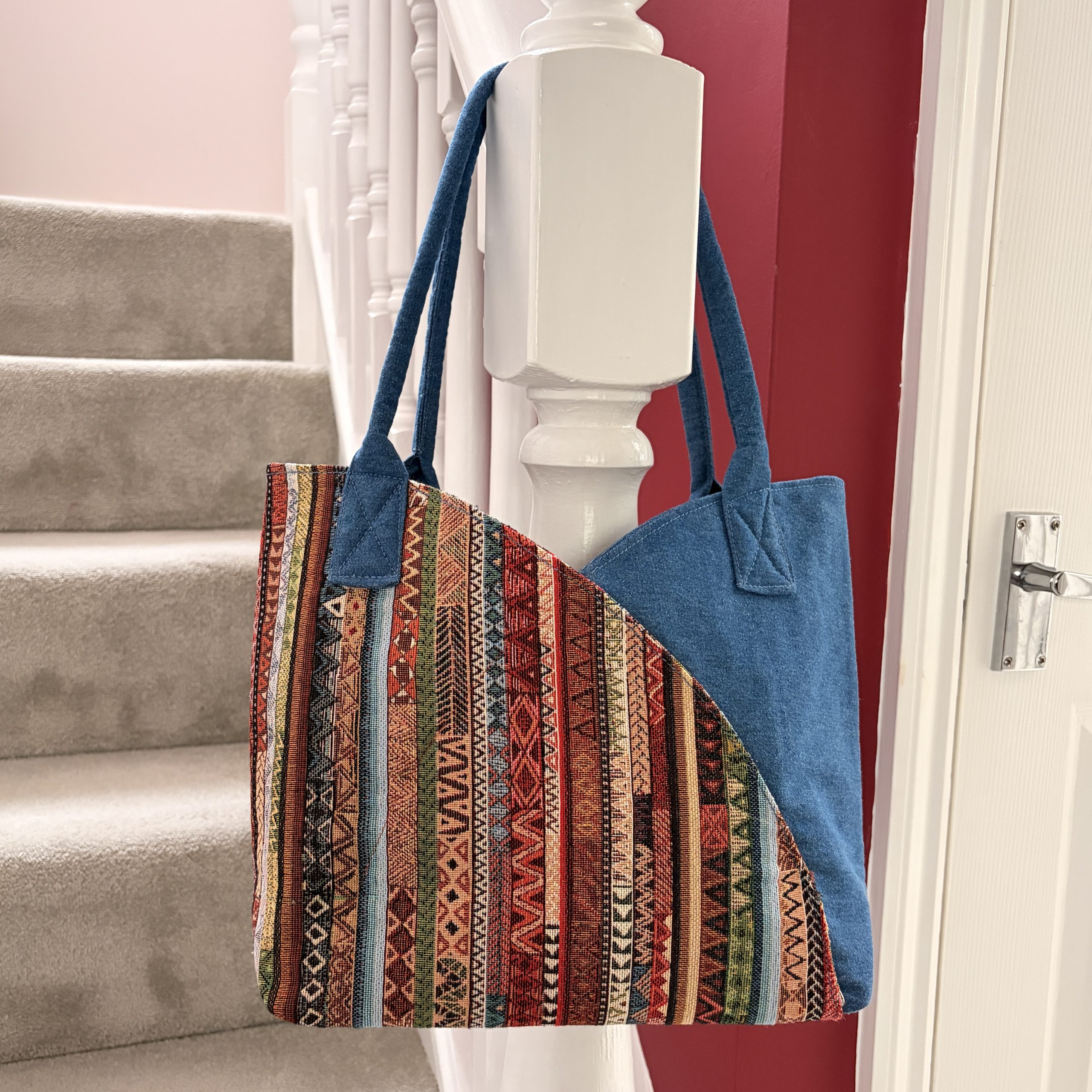 Handmade bag making - autumn colours with blue handles hanging on a stair banister