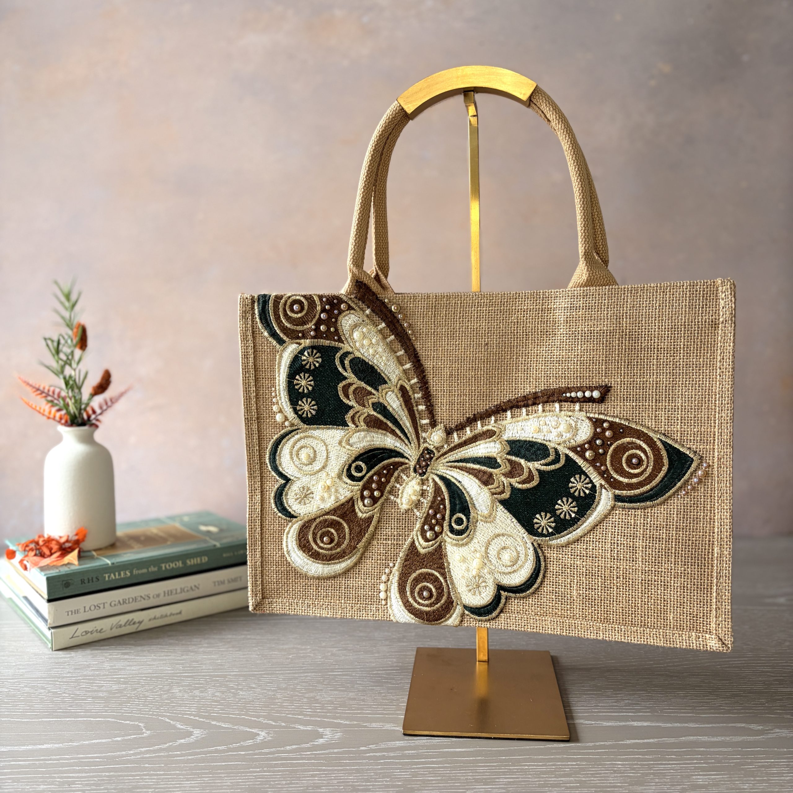 Butterfly jute bag with large embroidered green, brown and cream butterfly appliqué, hand embellished by Pomme d’Or.