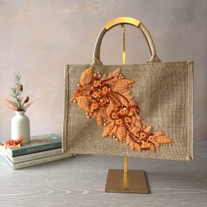 Orange floral jute bag with beaded and sequin botanical appliqué, hand embellished by Pomme d’Or.