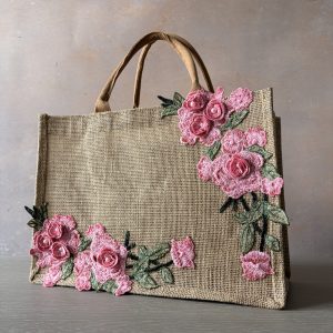 Pink floral jute bag with embroidered flowers, green leaves and pearl detailing, hand embellished by Pomme d’Or.