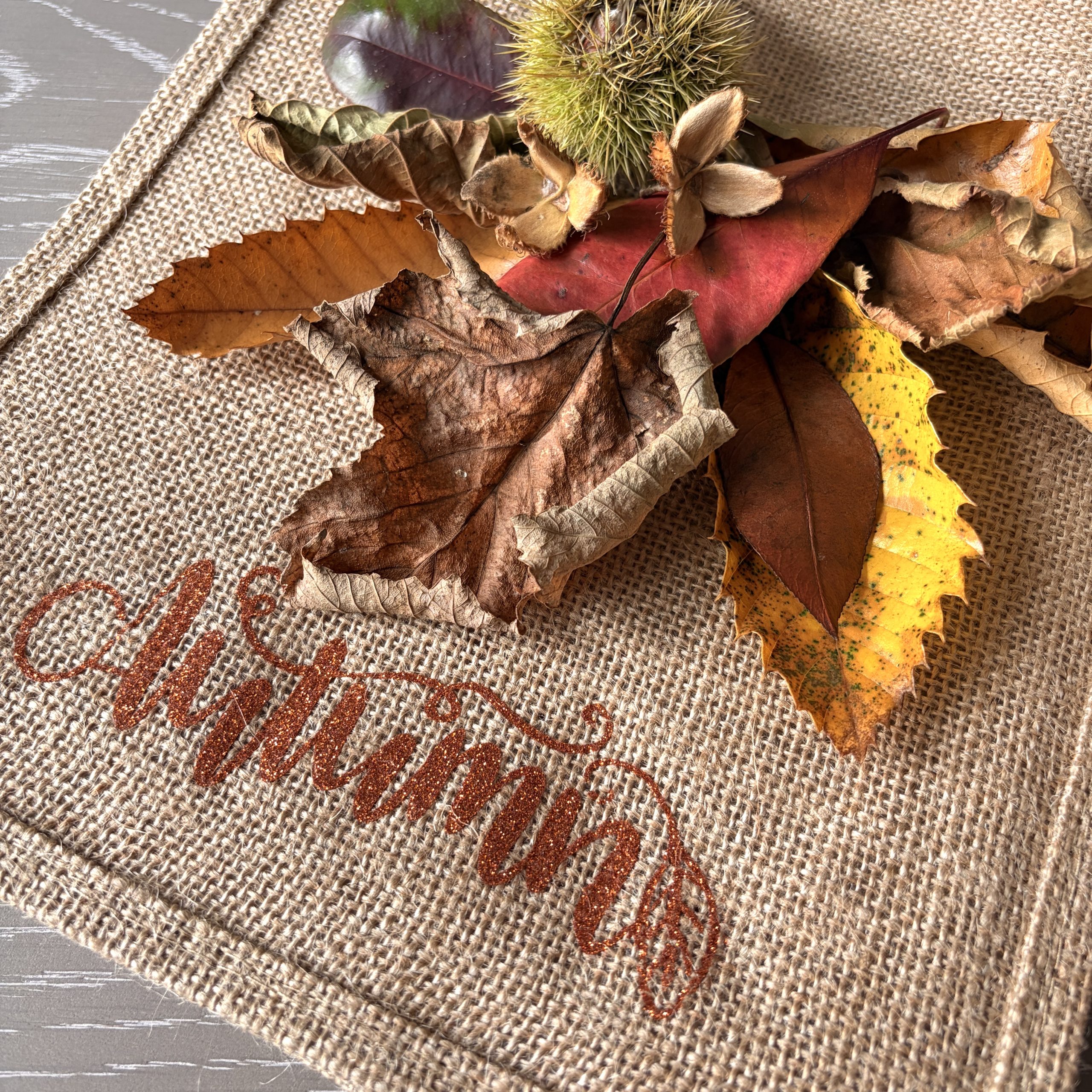 Autumn leaves resting on a Pomme d’Or jute bag